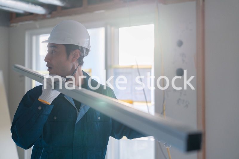 建設現場で資材を運ぶ男性の職人