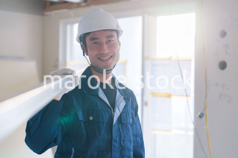建設現場で資材を運ぶ男性の職人