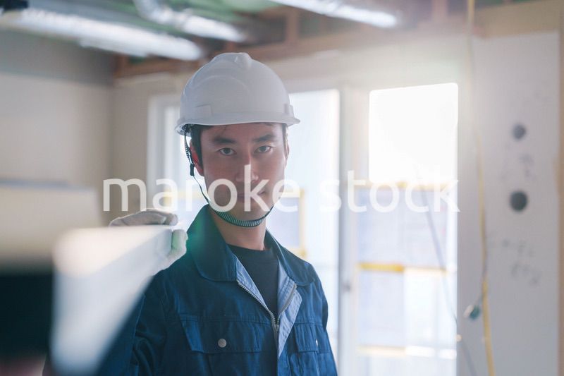 建設現場で資材を運ぶ男性の職人