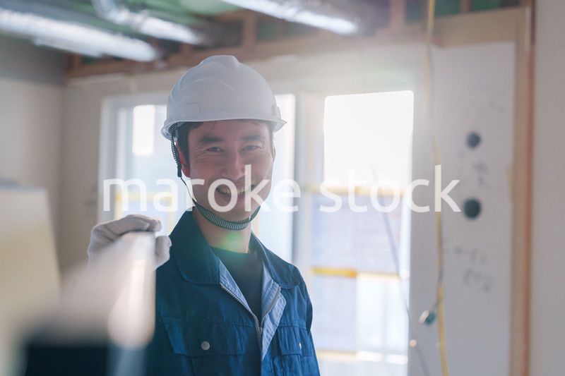 建設現場で資材を運ぶ男性の職人
