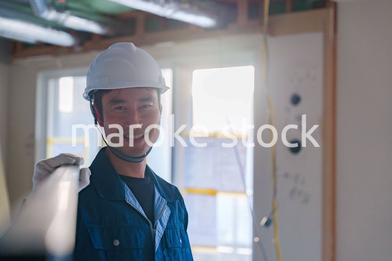 建設現場で資材を運ぶ男性の職人