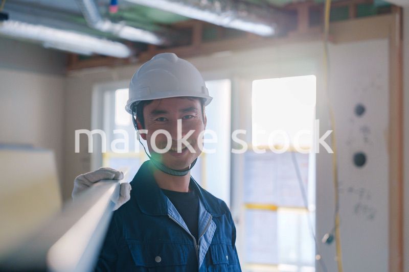 建設現場で資材を運ぶ男性の職人
