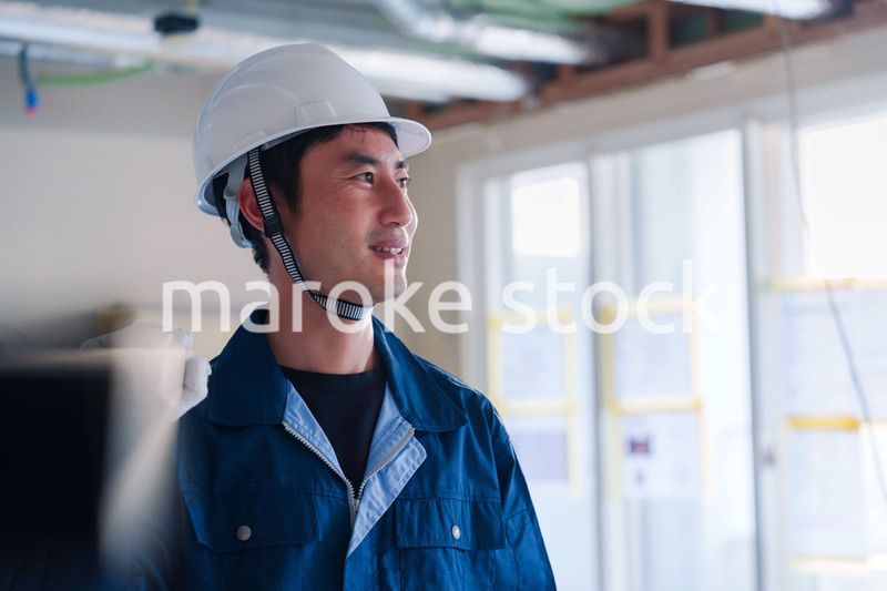 建設現場で資材を運ぶ男性の職人