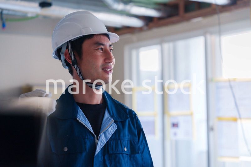 建設現場で資材を運ぶ男性の職人