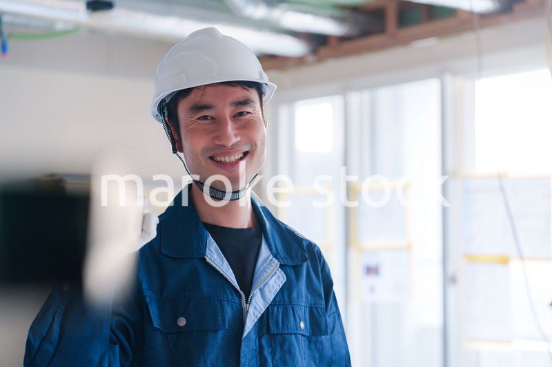 建設現場で資材を運ぶ男性の職人