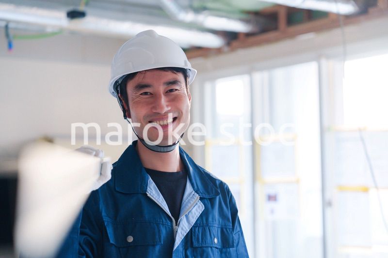 建設現場で資材を運ぶ男性の職人