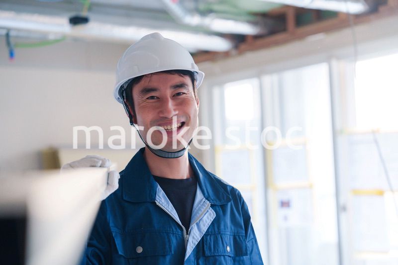建設現場で資材を運ぶ男性の職人