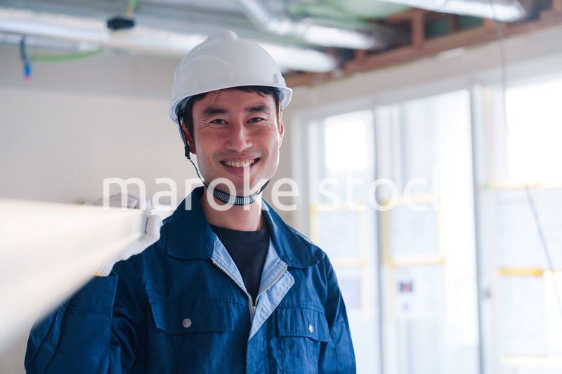 建設現場で資材を運ぶ男性の職人