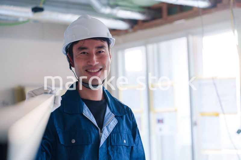 建設現場で資材を運ぶ男性の職人
