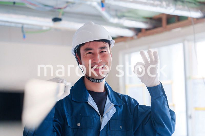 建設現場で資材を運ぶ男性の職人