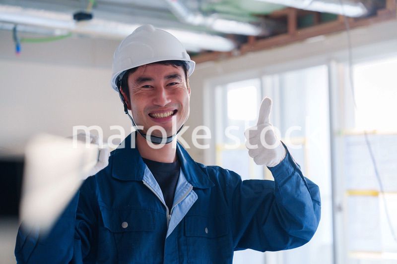 建設現場で資材を運ぶ男性の職人