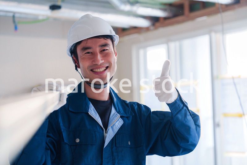 建設現場で資材を運ぶ男性の職人