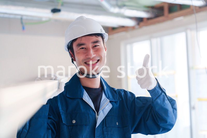 建設現場で資材を運ぶ男性の職人