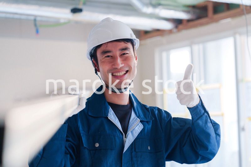 建設現場で資材を運ぶ男性の職人