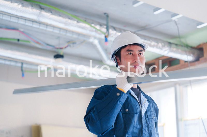 建設現場で資材を運ぶ男性の職人