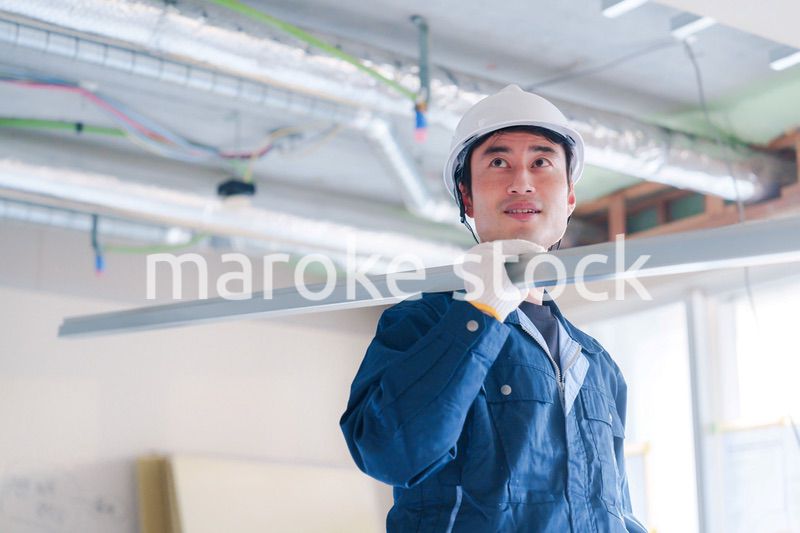 建設現場で資材を運ぶ男性の職人