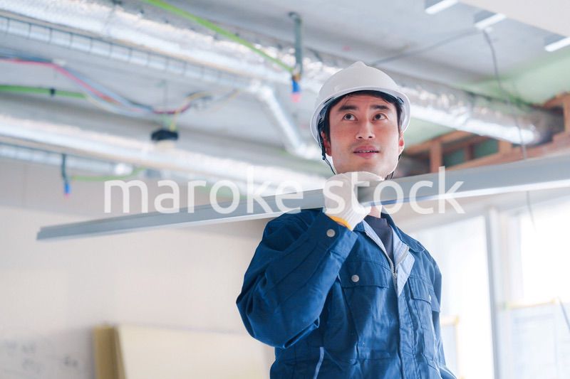 建設現場で資材を運ぶ男性の職人
