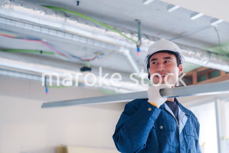 建設現場で資材を運ぶ男性の職人