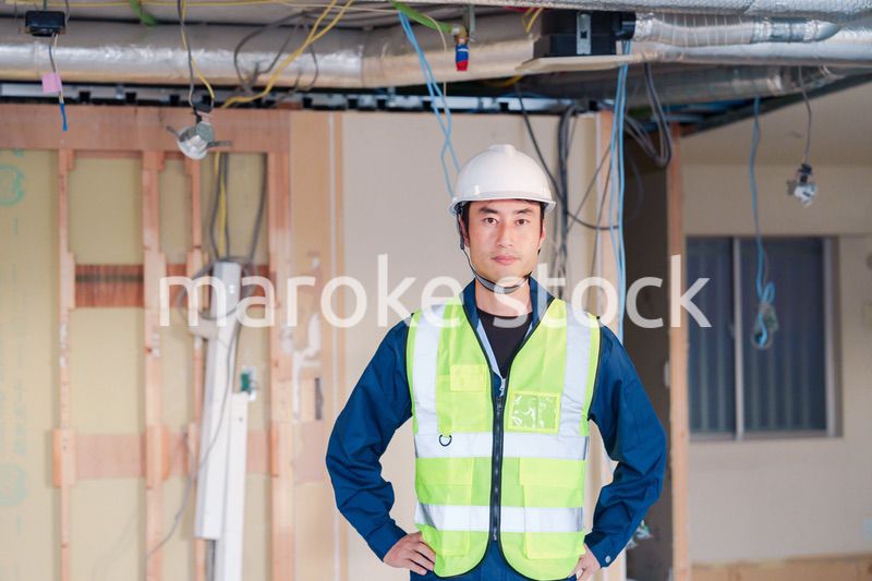 工事現場で安全服を着て作業をする男性大工