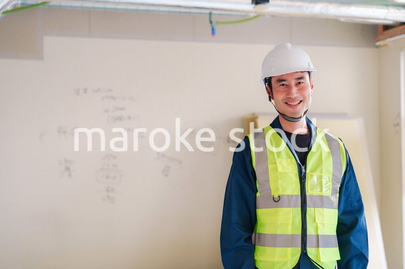 工事現場で安全服を着て作業をする男性大工