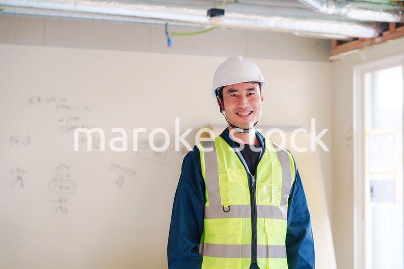 工事現場で安全服を着て作業をする男性大工