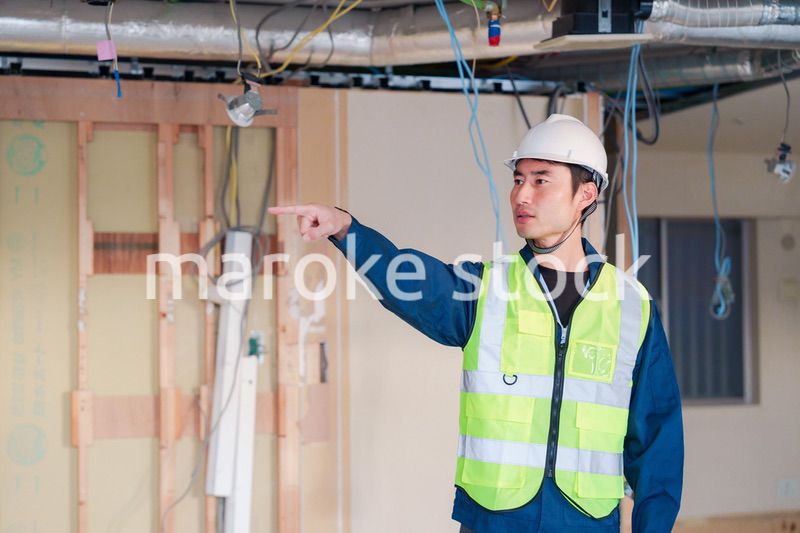 工事現場で安全服を着て作業をする男性大工