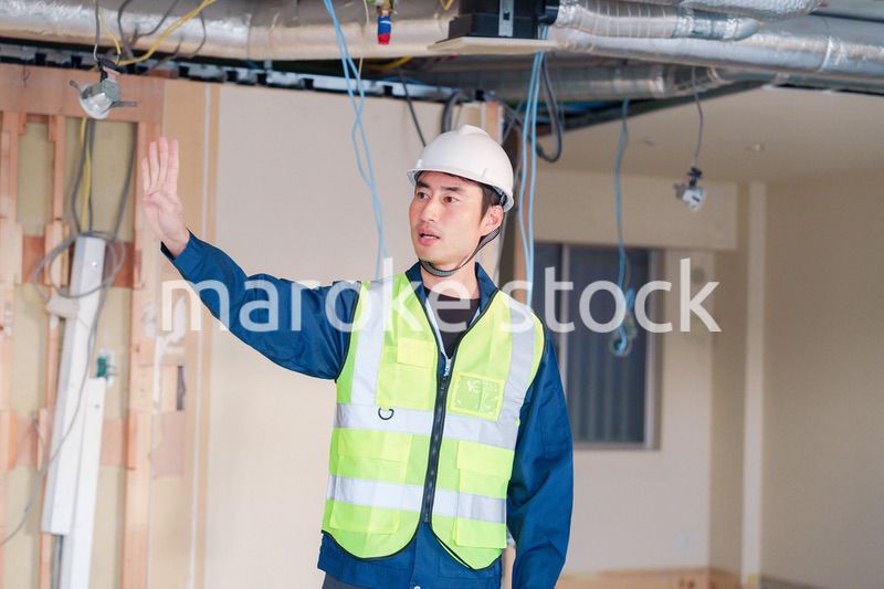 工事現場で安全服を着て作業をする男性大工