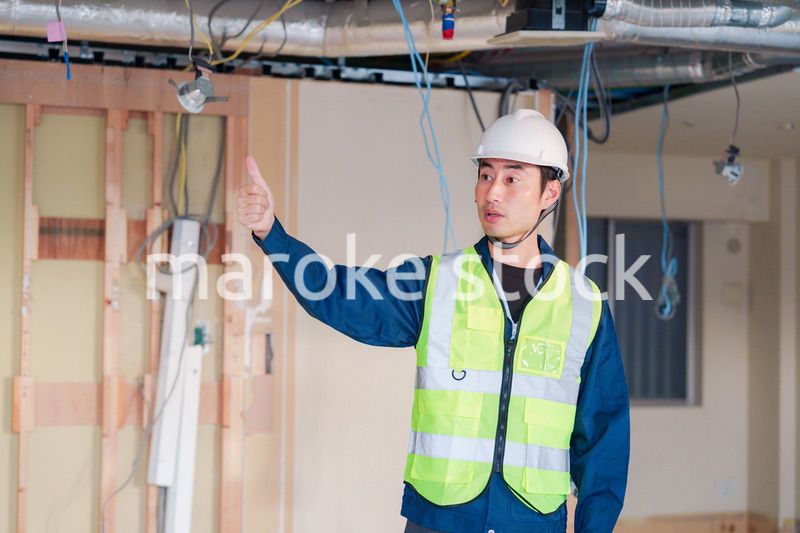 工事現場で安全服を着て作業をする男性大工