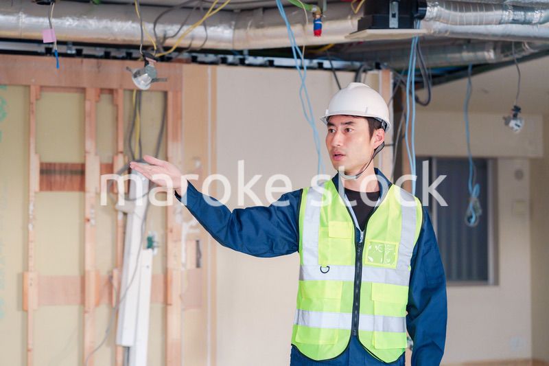 工事現場で安全服を着て作業をする男性大工