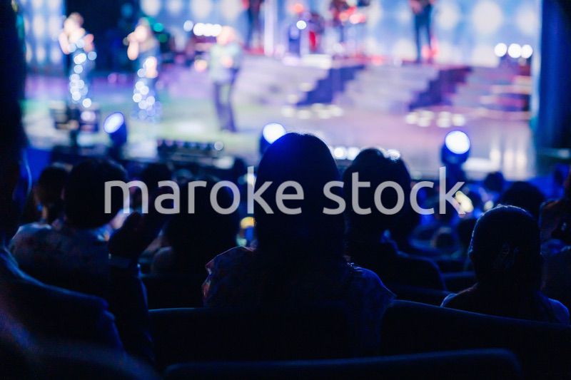 ホールでライブパフォーマンスを鑑賞する客