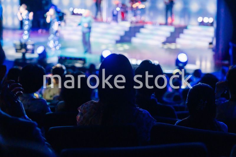 ホールでライブパフォーマンスを鑑賞する客
