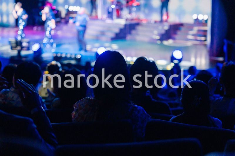 ホールでライブパフォーマンスを鑑賞する客