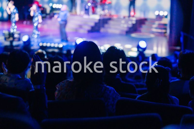 ホールでライブパフォーマンスを鑑賞する客