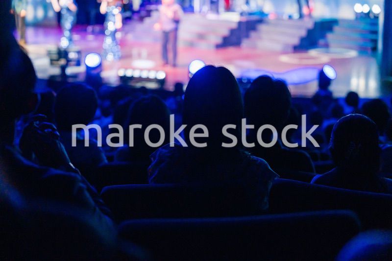 ホールでライブパフォーマンスを鑑賞する客