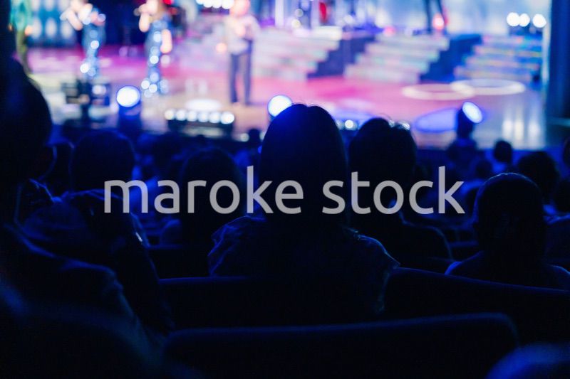 ホールでライブパフォーマンスを鑑賞する客