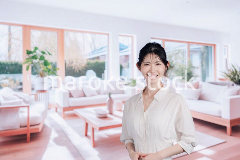 明るいリビングで過ごす若い女性