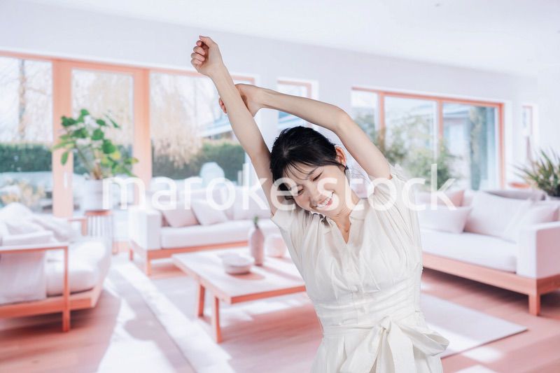 明るいリビングで過ごす若い女性
