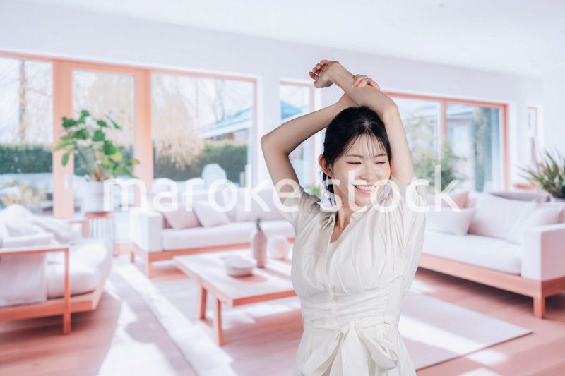 明るいリビングで過ごす若い女性