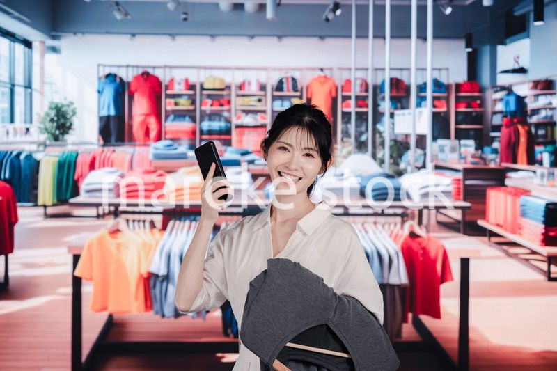 服屋さんで買い物をする若い女性