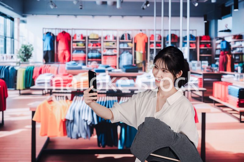 服屋さんで買い物をする若い女性