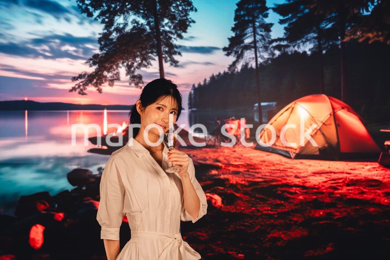 キャンプをしながらお酒を飲む若い女性