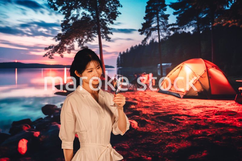 キャンプをしながらお酒を飲む若い女性