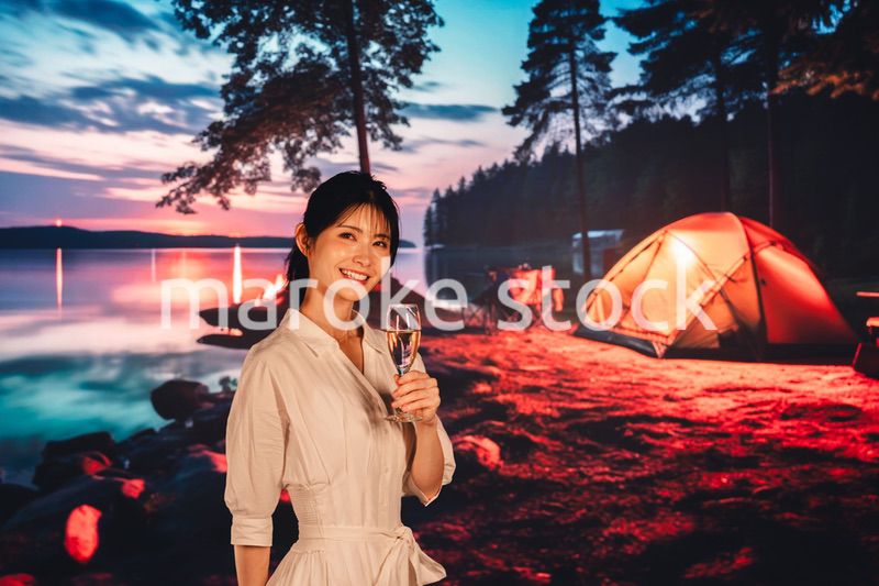 キャンプをしながらお酒を飲む若い女性