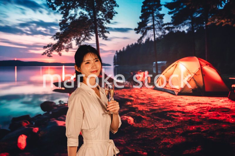 キャンプをしながらお酒を飲む若い女性