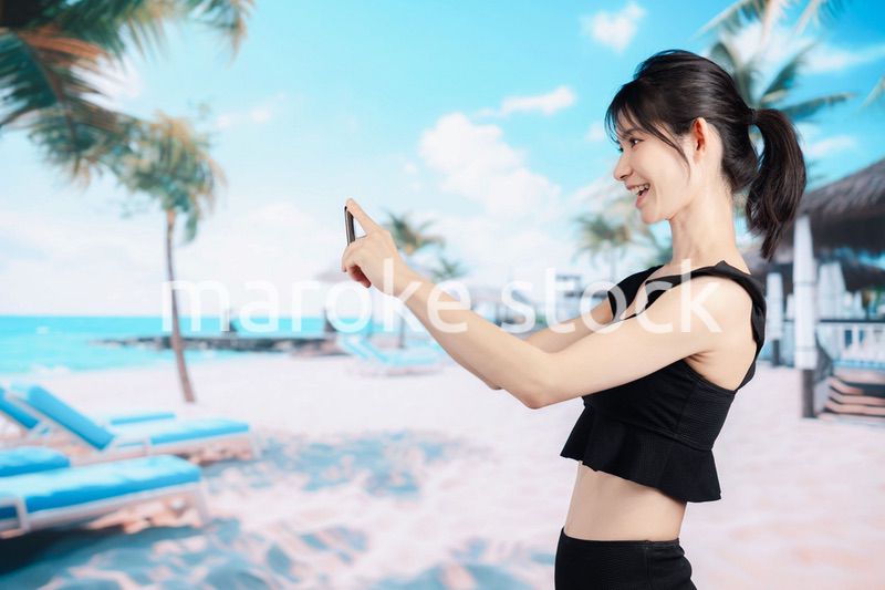 ビーチで自撮りをする若い女性