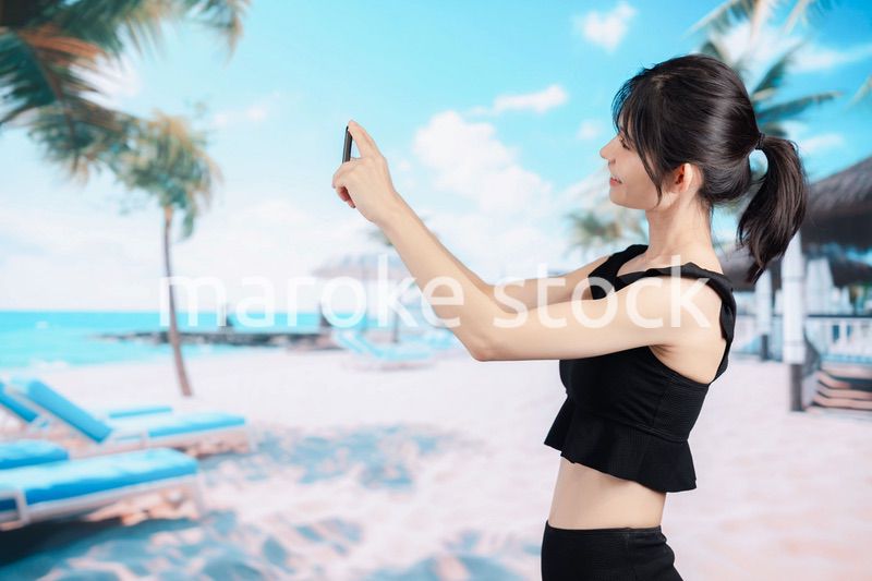 ビーチで自撮りをする若い女性