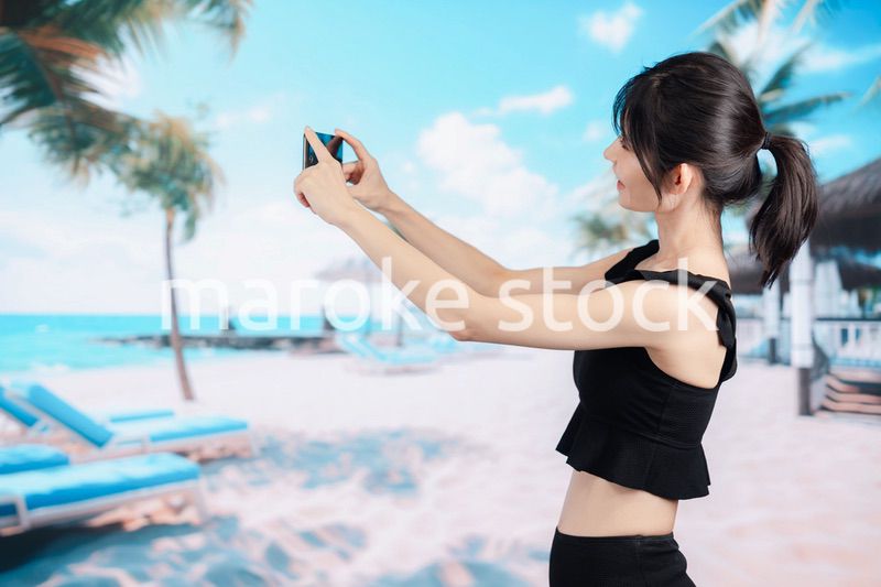 ビーチで自撮りをする若い女性