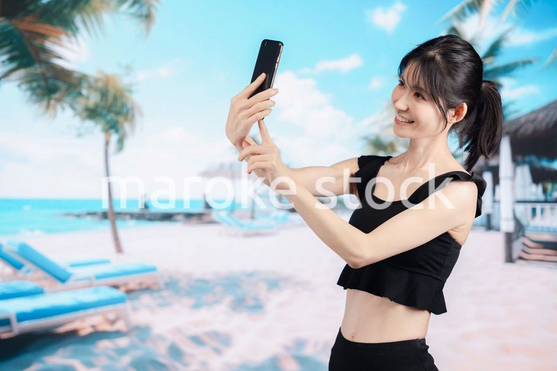 ビーチで自撮りをする若い女性