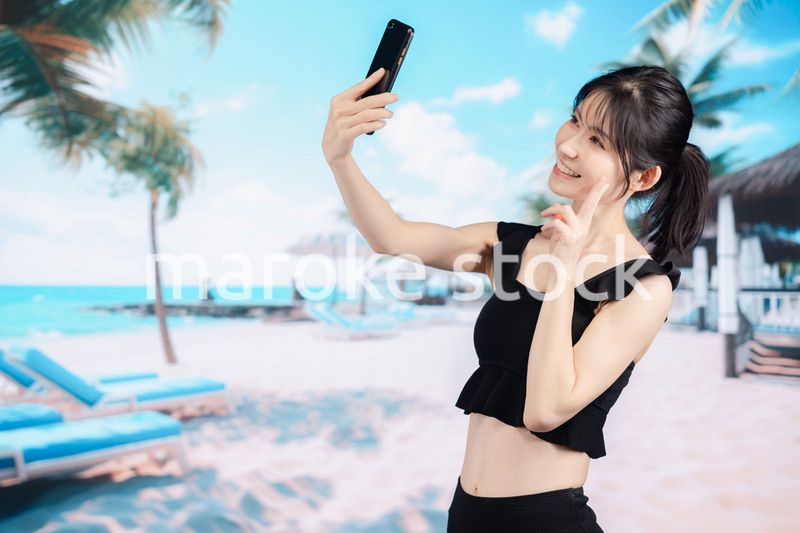 ビーチで自撮りをする若い女性