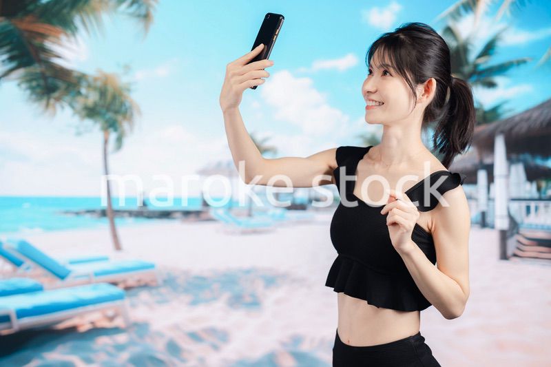 ビーチで自撮りをする若い女性